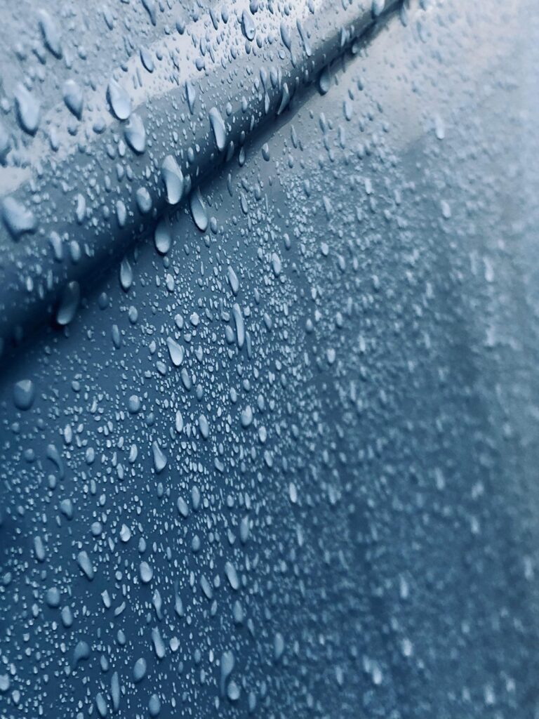 Close-up view of water droplets on a smooth surface, showcasing texture and clarity.